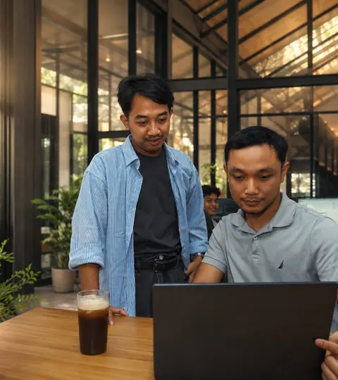 Two Doodex Odoo developers reviewing code on a laptop in the studio