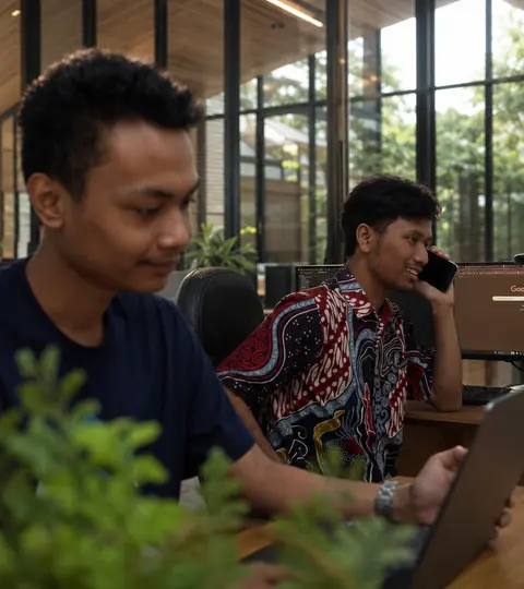 Doodex developer on a client call while a colleague works on an Odoo module